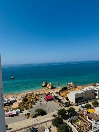 a view of a beach with a parking lot and the ocean at Concorde Luxury Ocean View in Portimão