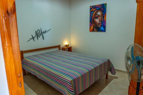 ein Schlafzimmer mit einem Bett und einem Gemälde an der Wand in der Unterkunft Luarca 80 in Santa Clara del Mar