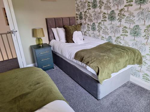 a bedroom with a bed and a nightstand with a bed sidx sidx sidx sidx at Fieldside House Beautiful Sleeps 6 House with Decked Garden in Scarborough