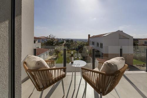 a balcony with chairs and a table on a balcony at Quinta Atia in Caldas da Rainha