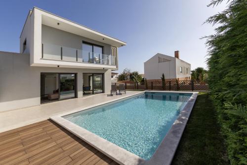 a house with a swimming pool in front of a house at Quinta Atia in Caldas da Rainha