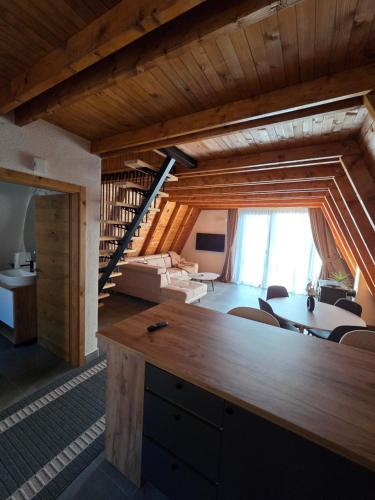 a living room with a table and chairs and a staircase at Kozara Resort in Gornji Podgradci
