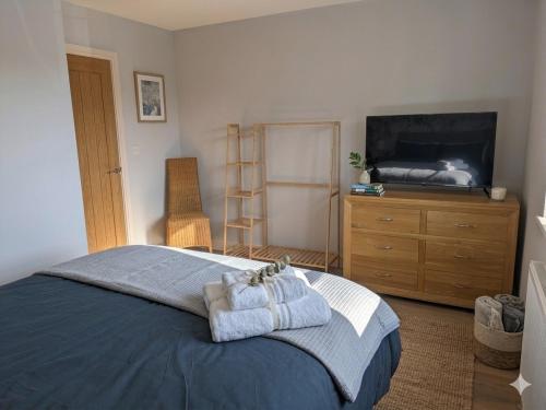 a bedroom with a bed and a dresser and a television at Beachwood in Skegness