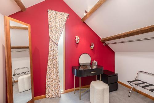 a room with red walls and a vanity and a mirror at The Barn at Noelles Cottages in Pickering