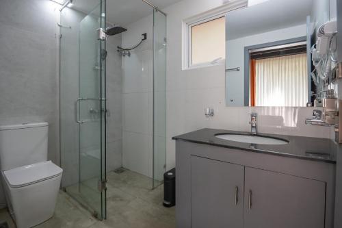 a bathroom with a toilet and a sink and a shower at Leopard Eye Resort in Kitulgala