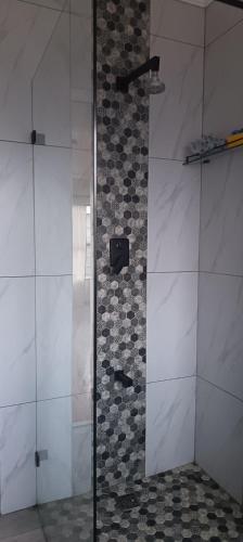 a shower in a bathroom with a tile wall at Large ensuite room in Goodwood