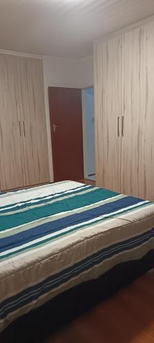 a bedroom with a large bed with wooden cabinets at Large ensuite room in Goodwood