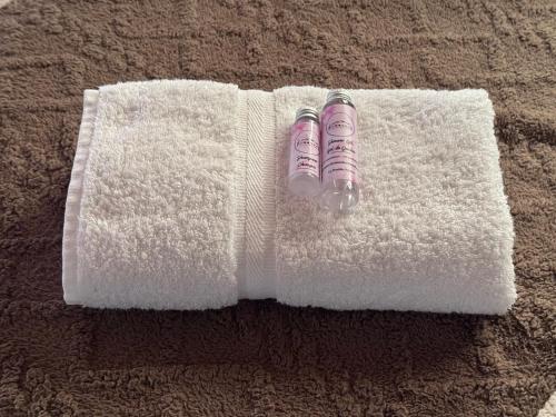 a white towel with a bottle on top of it at Kumanday Lodge in Pereira