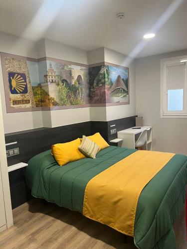 a bedroom with a bed with yellow and green sheets at Pension San Anton in Melide