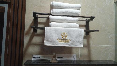 a group of towels on a towel rack in a bathroom at Murugammal residency in Tiruppatūr