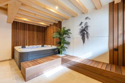 a bathroom with a tub and a plant in it at Chalet Cocooning avec SPA Les Granges de Thuy in Thônes