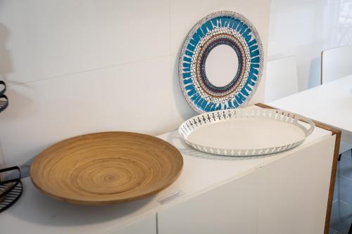 a counter with two plates and a mirror on it at Refugio do Outeiro - by Smarthomes in São Martinho do Porto