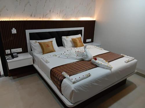 a bedroom with a large white bed with pillows at Murugammal residency in Tiruppatūr