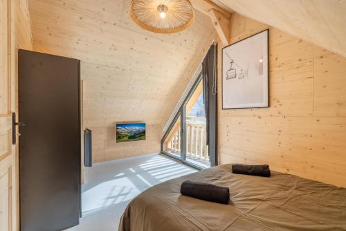 a bedroom with a bed and a large window at Chalet Cocooning avec SPA Les Granges de Thuy in Thônes