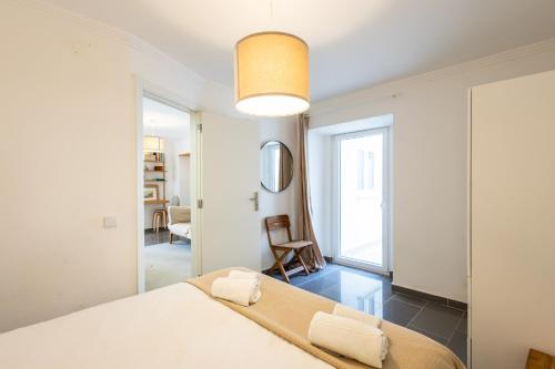 a bedroom with a large white bed with two towels at Refugio do Outeiro - by Smarthomes in São Martinho do Porto
