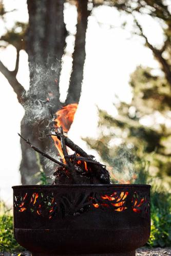 a fire in a black pot with flames in it at Tiny family getaway - breathe in the country air in Glenquarry