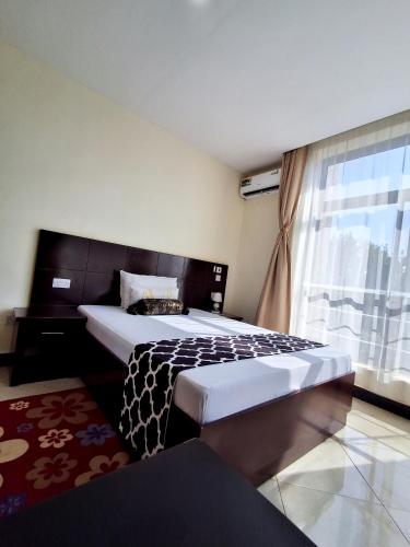 a bedroom with a large bed and a window at Snow View Residences in Msaranga