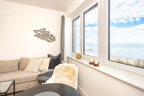 a living room with a view of the ocean at Ostsee Suite 4 - Strandperle in Niendorf