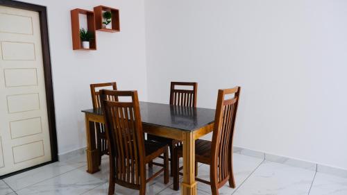 a dining room table and chairs with a black table at Eettickal Homes in Ūdumbanshola