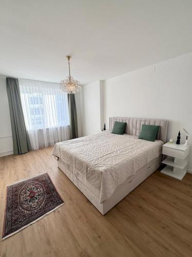 a white bedroom with a large bed and a chandelier at Urlaub am Bodensee in Staad - einmalige Seesicht in Staad