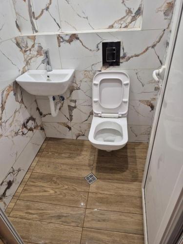 a bathroom with a toilet and a sink at Апартамент Сиракови Черноморец in Chernomorets