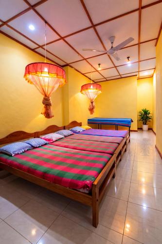a large bed in a room with two lights at Lavanya Holiday Resort Kataragama in Kataragama