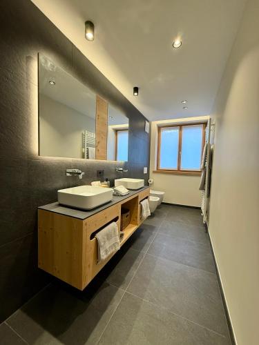 a bathroom with two sinks and a large mirror at Appartamento Rododendro in Andalo