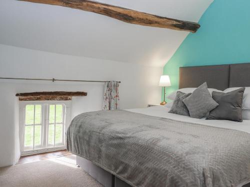a bedroom with a large bed and a window at Westacombe Farmhouse in Exeter