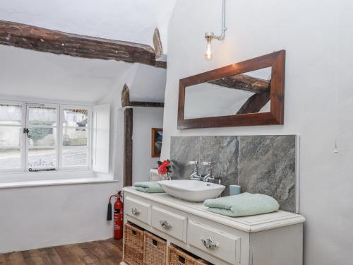 a bathroom with a sink and a mirror at Westacombe Farmhouse in Exeter