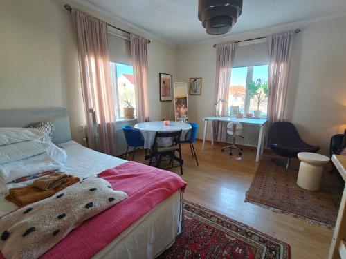 a bedroom with a bed and a table and chairs at Rymlig 2-rumssvit nära Centralstationen - Anna Josefinas Stay in Umeå