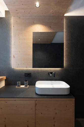 a bathroom with a sink and a mirror at Appartamento Erica in Andalo