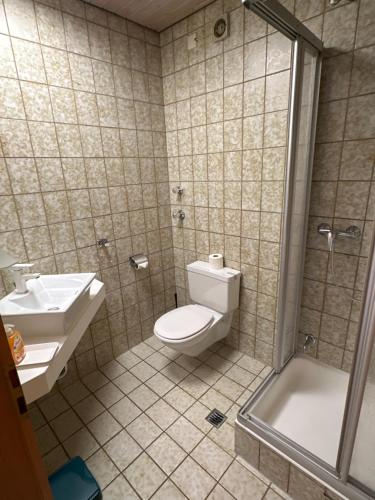 a bathroom with a toilet and a sink and a shower at Eiscafé - Pizzeria Antonio in Lichtenau
