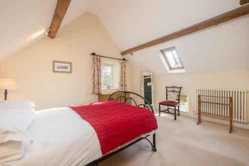 a bedroom with a large bed with a red blanket at The Coach House at Noelles Cottages in Pickering