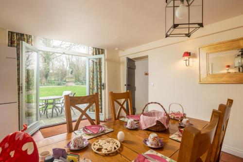 a dining room with a table and a window at The Coach House at Noelles Cottages in Pickering