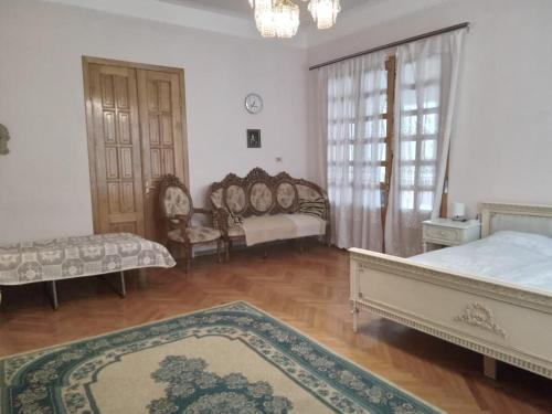 a bedroom with two beds and a couch and chairs at Tilda&Matilda in Kutaisi