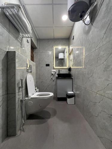 a bathroom with a toilet and a sink and a mirror at Luxury Villa in Falnir in Mangalore