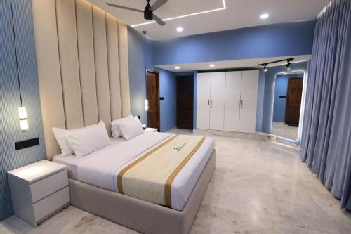 a bedroom with a large bed and blue walls at Luxury Villa in Falnir in Mangalore