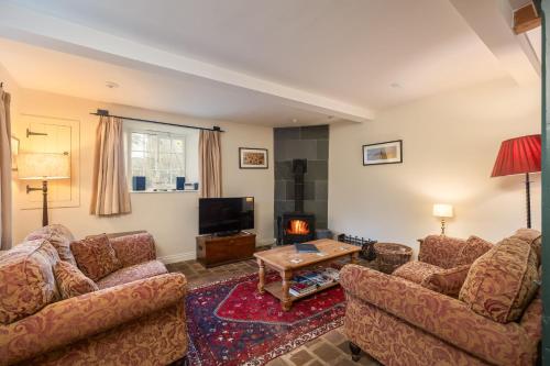 a living room with two couches and a tv at The Coach House at Noelles Cottages in Pickering