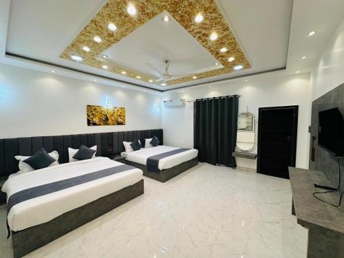 a hotel room with two beds and a television at Hotel Panna Haveli in Jaipur