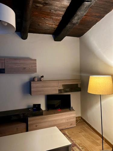 a living room with a tv and a table and a lamp at Casetta n'da civita in Castrovillari