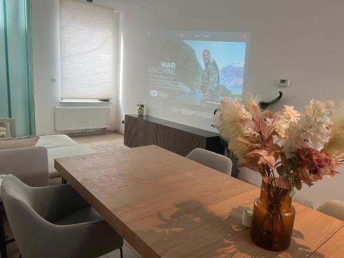 a living room with a table and a movie screen at Holiday house with private jaccuzi - Leuven city center in Leuven