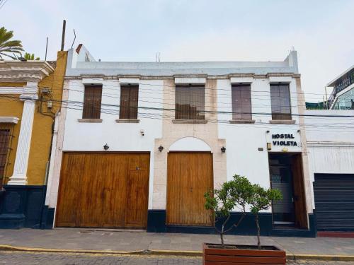 an old building with wooden doors on a street at Hostal Violeta in Arequipa