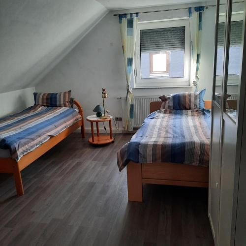 a bedroom with two beds and a window at Farbenfrohe Dachgeschoßwohnung in Giesen
