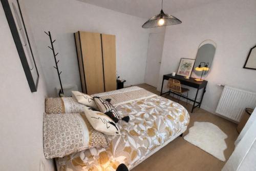 una camera da letto con un letto e un tavolo con uno specchio di L'Instant Cocoon central-parking-4prs a Bourg-en-Bresse