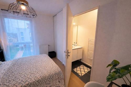 una piccola camera da letto con un letto e una finestra di L'Instant Cocoon central-parking-4prs a Bourg-en-Bresse