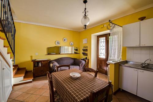 a living room with a table and a kitchen at Cottage House Il Palazzetto in Castelnuovo di Garfagnana