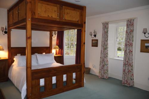 a bedroom with a wooden bunk bed and a window at Forget Me Not Holiday Cottage in Dalmellington