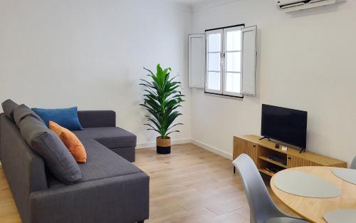 a living room with a couch and a tv at Casa João de Quintal in Elvas