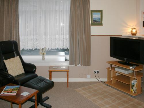 a living room with a couch and a television at Macdonald Cottage in Balnald