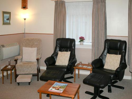 a living room with two chairs and a table at Macdonald Cottage in Balnald